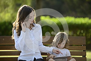 Mother on phone with daughter using digital tablet