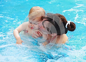 Mother play with her child in swimming-pool