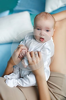 Mother playing with baby lying on bed