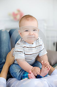 Mother playing with baby lying on bed