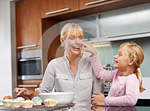 Mother playing, flour or girl baking in kitchen or happy family with an excited child learning cupcake recipe. Home