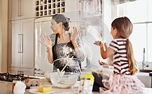 Mother, playing or girl baking in kitchen as a happy family with a playful young kid with flour at home. Dirty, messy or