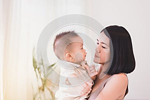 Mother playing with her asian baby boy in the bedroom,Happy new born kid and family