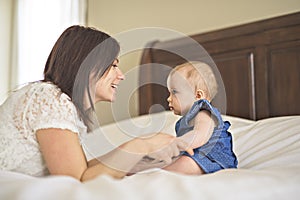 Mother playing with her baby in the bedroom