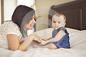 Mother playing with her baby in the bedroom