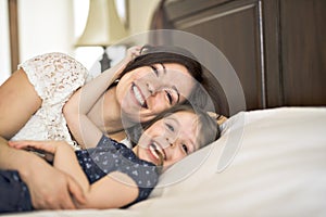 Mother playing with her baby in the bedroom