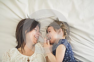 Mother playing with her baby in the bedroom