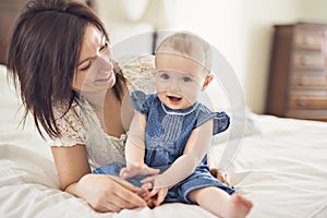 Mother playing with her baby in the bedroom