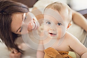 Mother playing with her baby in the bedroom