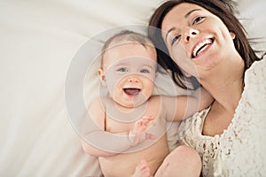 Mother playing with her baby in the bedroom