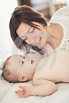 Mother playing with her baby in the bedroom