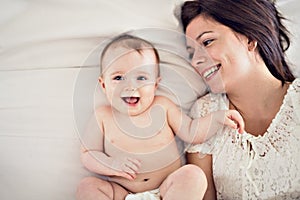 Mother playing with her baby in the bedroom