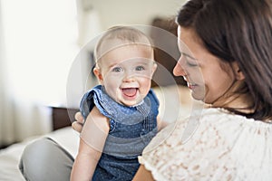 Mother playing with her baby in the bedroom