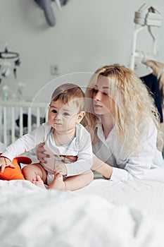 Mother playing with her baby in the bedroom