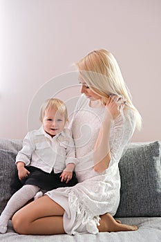 Mother playing with her baby in the bedroom.