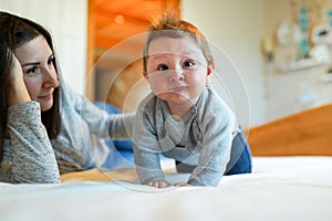 Mother playing with her baby in the bedroom. happy family