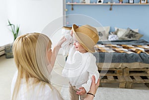 Mother playing with her baby in the bedroom. Happy loving family.