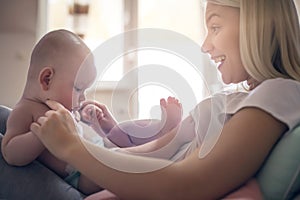 Mother playing with her baby boy at home.