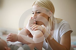 Mother playing with her baby boy at home.