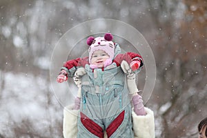 Mother playing with her baby in winter garden