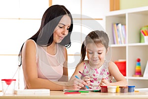 Mother playing with her child daughter, drawing together