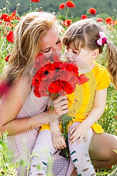 Mother playing with her child in poppy field