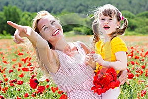 Mother playing with her child in poppy field