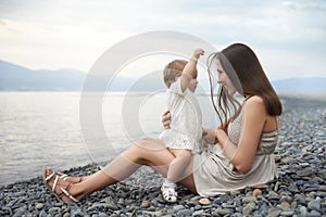 Mother playing with her daughter on the beach