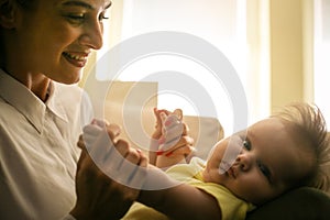 Mother playing with her little girl at home. Close up.