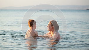 Mother playing with her young son in the sea