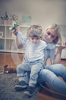 Mother playing in living room with her son.