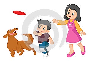 a mother is playing and throws a frisbee at a boy and is followed by her dog photo
