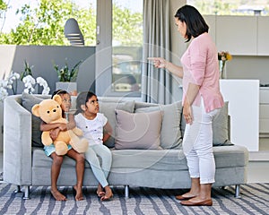Mother, pointing and scolding child in home, discipline and communication or strict parent in family house. Living room