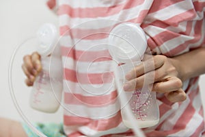 Mother pumping breastmilk into bottles