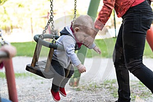 Mother Pushing Baby Boy Having Fun on Swing