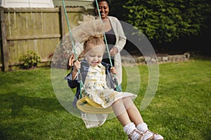 Mother Pushing Daugher on a Swing