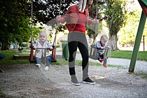 Mother Pushing Her Baby`s Having Fun on Swing