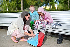 Mother puts children on her feet roller skates