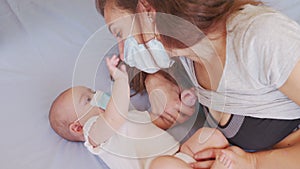 Mother putting on Protective mask to her son to protect from Corona virus or Covid-19 virus outbreak. The baby in face