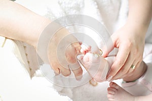 Mother putting a ring on her child's toe