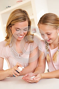 Mother putting sanitizer on young girl's hands