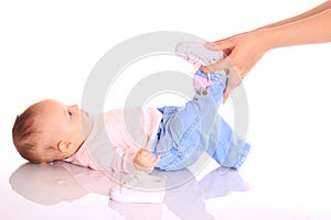 Mother putting shoes on baby