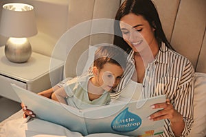 Mother reading bedtime story to her son at home