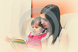 Mother reading a book with her little daughter