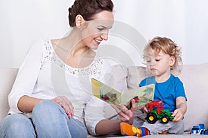 Mother reading book of her son