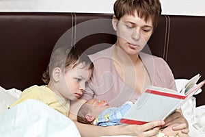 Mother reading book for her sons