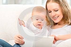 Mother reading a book a little baby on the sofa