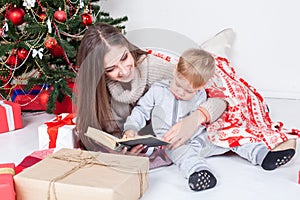 Mother reading a book to a child at Christmas new year