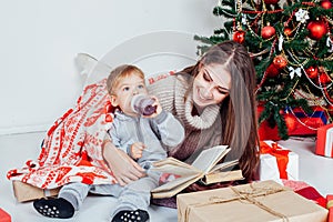 Mother reading a book to a child at Christmas new year