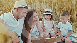 Mother reading book to children at picnic